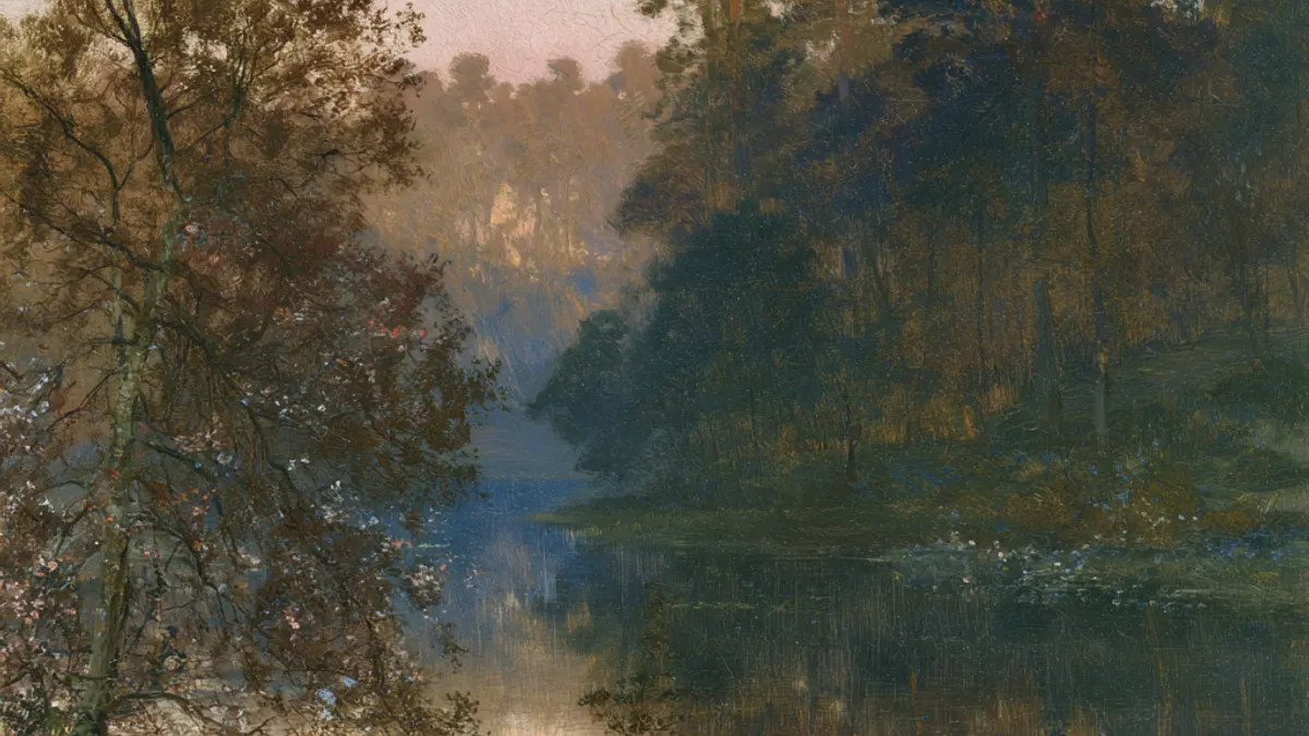 A still lake at dawn closed in on every side by dark woods